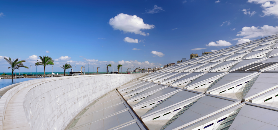 A panoramic view of the Bibliotheca Alexandrina in Alexandria, Egypt, showcasing its unique roof design and waterfront location.