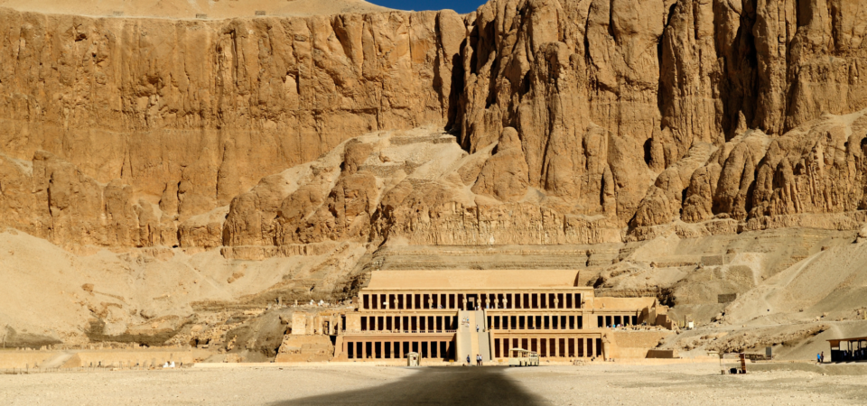 A wide-angle view of Hatshepsut Temple in Luxor, Egypt, showcasing its terraced structure and surrounding landscape.