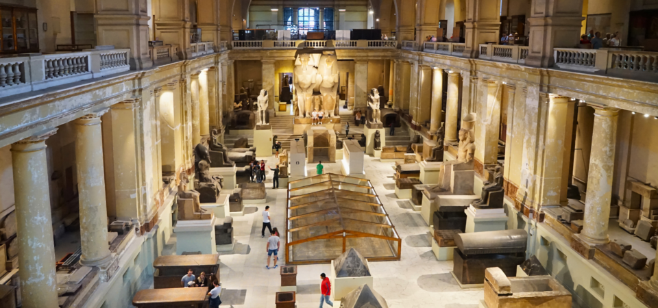 Inside the Egyptian Museum’s main hall, featuring large statues and ancient artifacts on display.