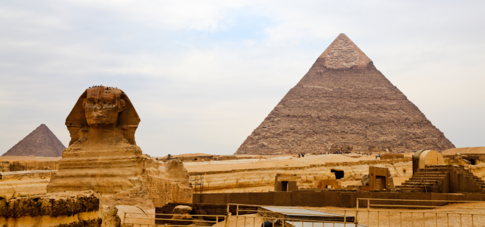 The Great Pyramid of Giza and the Sphinx, iconic ancient Egyptian monuments, standing in the Giza Necropolis.