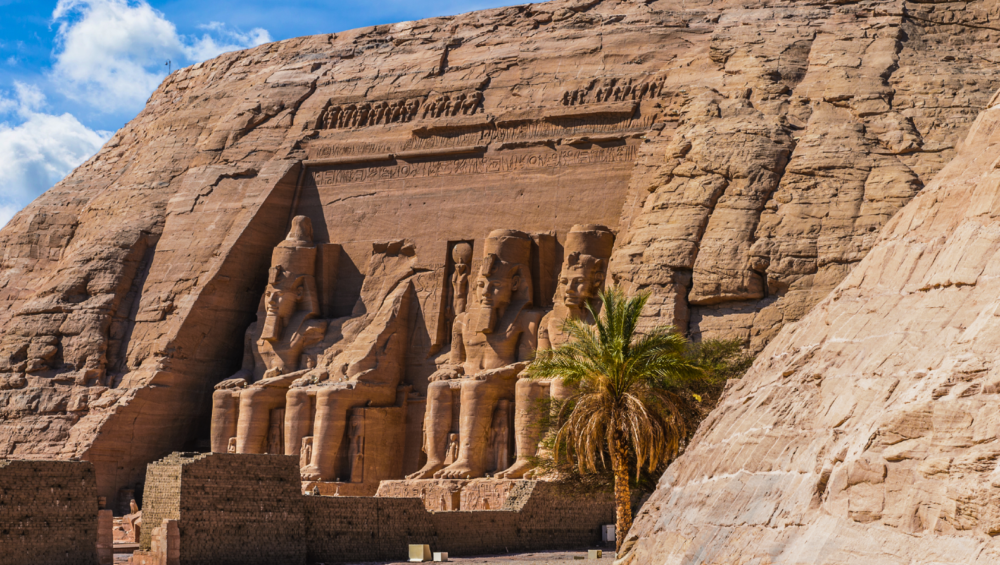 The grand façade of Abu Simbel Temple featuring four colossal statues of Pharaoh Ramses II.