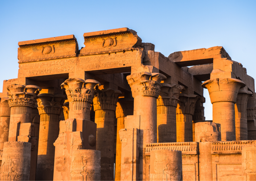 A photo of the Temple of Kom Ombo, showcasing the massive columns, the hieroglyphics on the walls, and the golden hour light.
