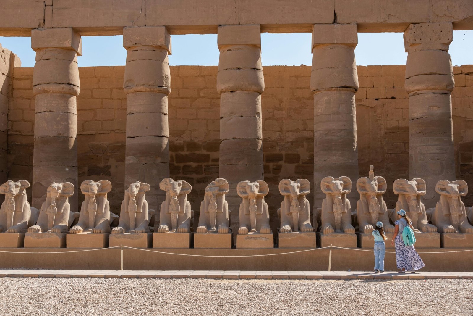 A photo of the Avenue of Sphinxes at Karnak Temple, showcasing rows of ram-headed sphinxes inside the temple.