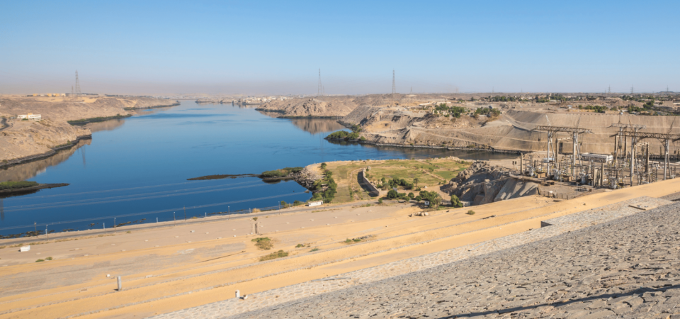 A panoramic view of Aswan High Dam and the calm waters of Lake Nasser stretching into the distance