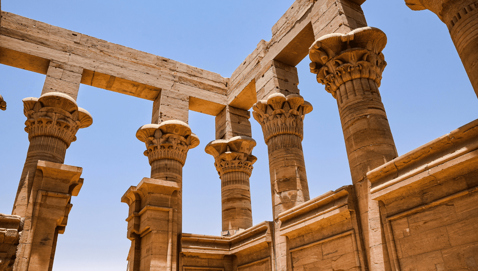 Close-up of ornate columns with floral capitals, set against a clear blue sky