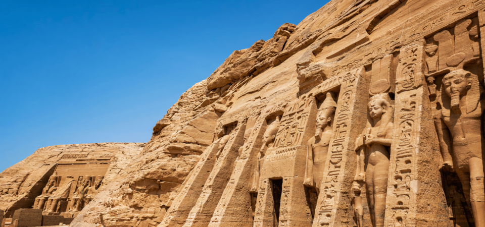 A panoramic view of the Great Temple of Ramses II at Abu Simbel, with detailed statues carved into the mountain.