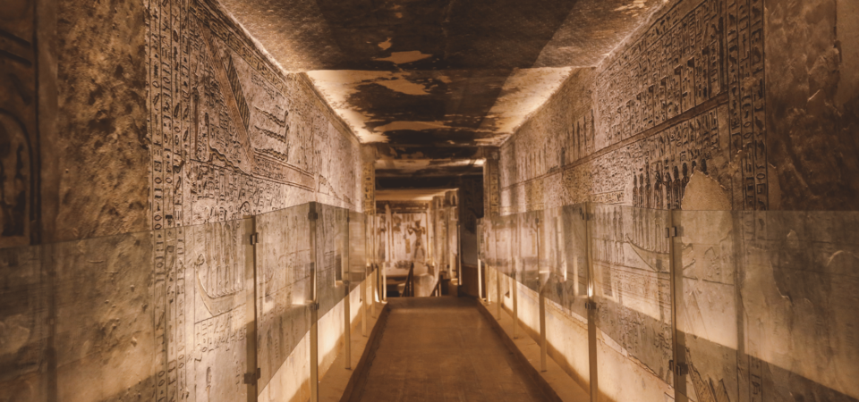 A richly decorated corridor inside the Valley of the Kings, lined with intricate hieroglyphs and carvings.