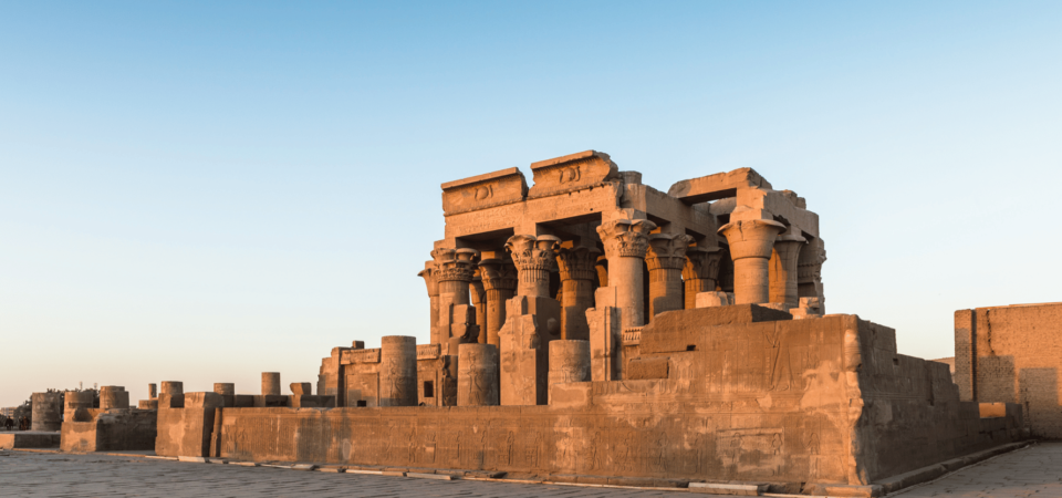 The twin temple of Kom Ombo, beautifully lit at sunset with towering columns.