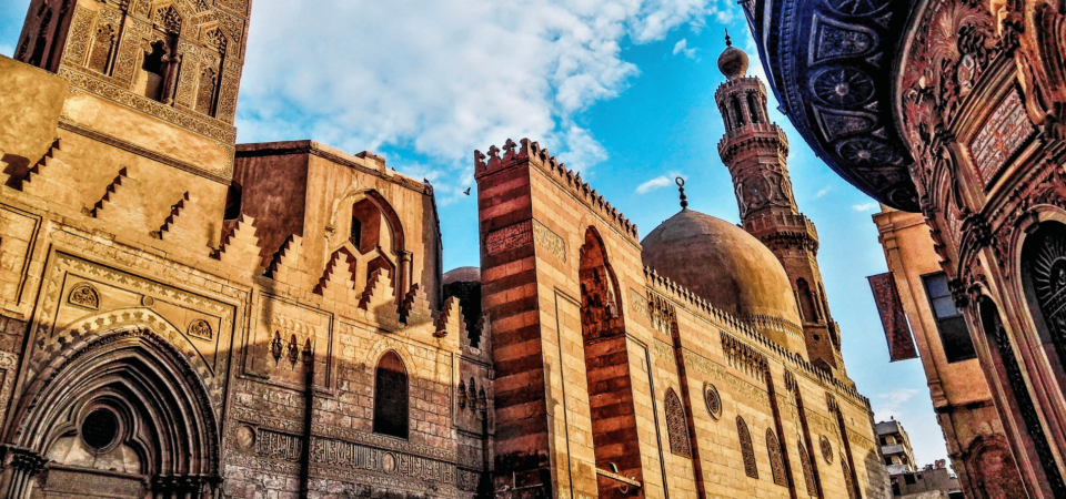 Ornate Islamic architecture along Al-Muizz Street, featuring historic domes, minarets, and intricate stone carvings.