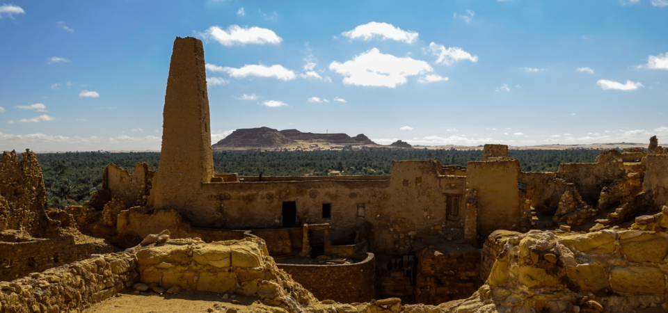 The Temple of Amun in Siwa, ancient ruins set against a backdrop of desert sands and clear blue skies.