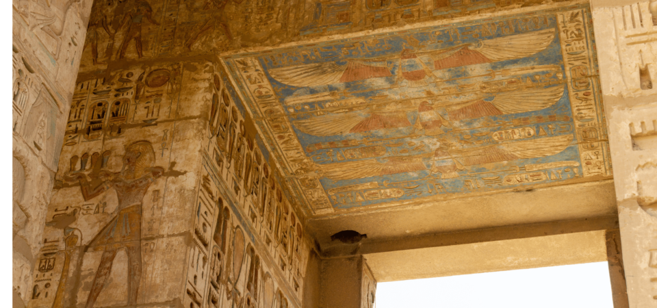 Vibrant winged solar disk motif on the ceiling of Medinet Habu Temple, Luxor, Egypt.