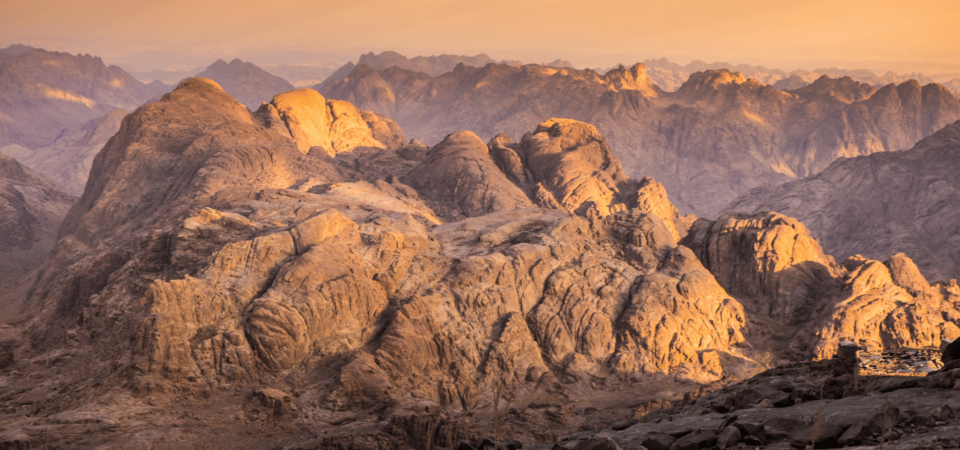 Golden hues illuminating the rugged peaks of Mount Sinai during sunset.