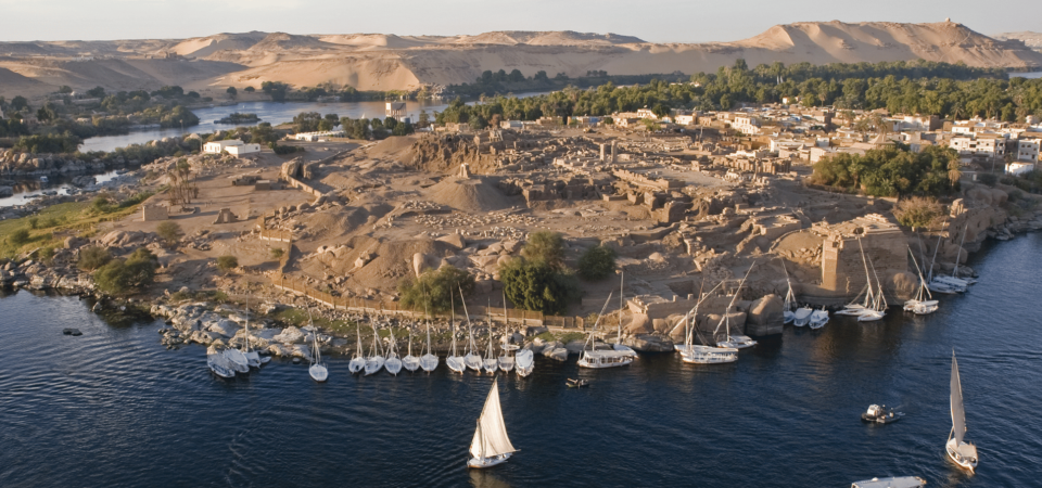 Aerial view of Elephantine Island with ancient ruins and sailboats docked along the Nile River.