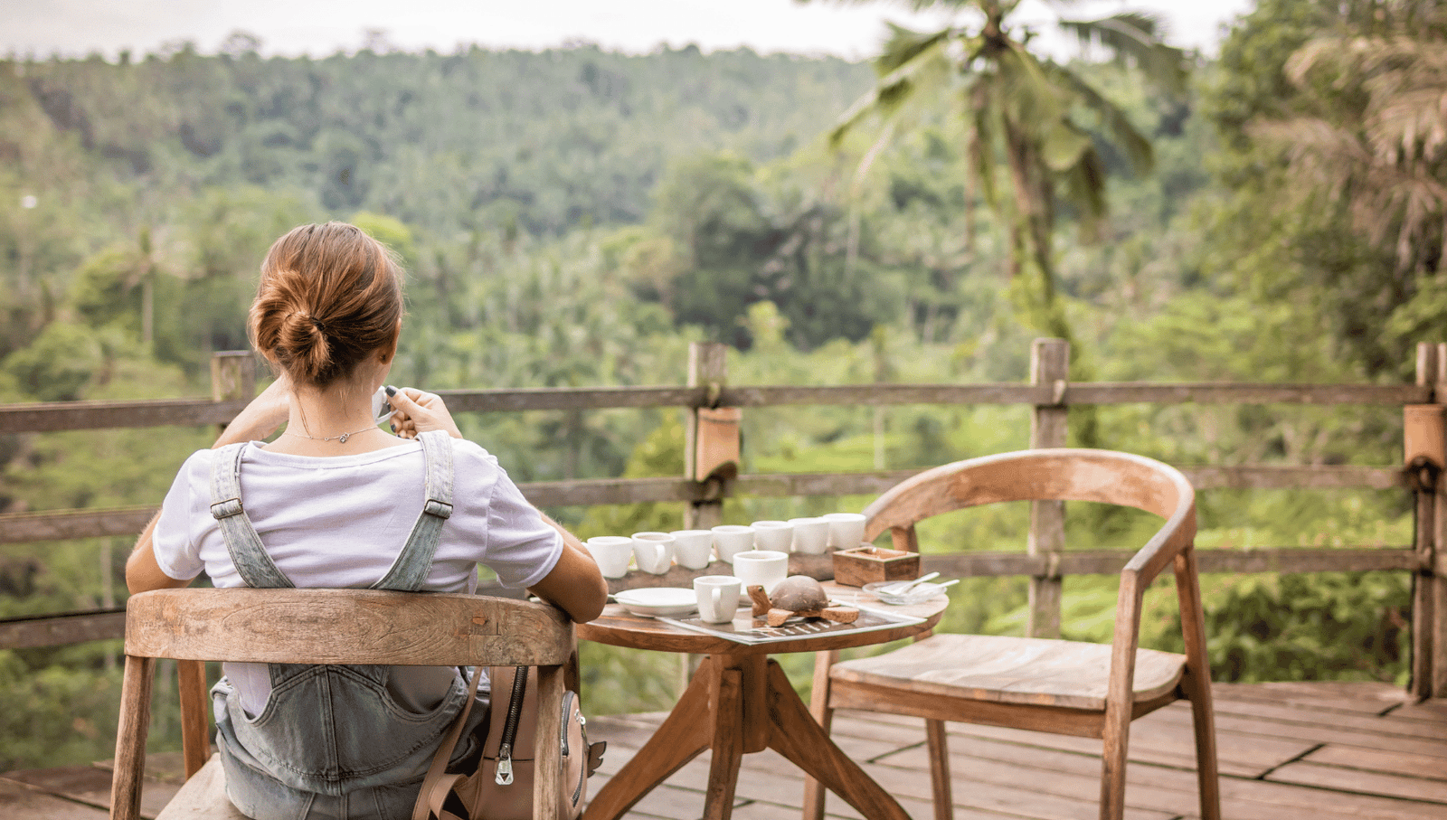 A woman enjoying a peaceful moment with tea, symbolizing the calming and meditative properties of the lotus flower in holistic healing.